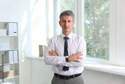 Portrait of middle aged man with crossed arms in office