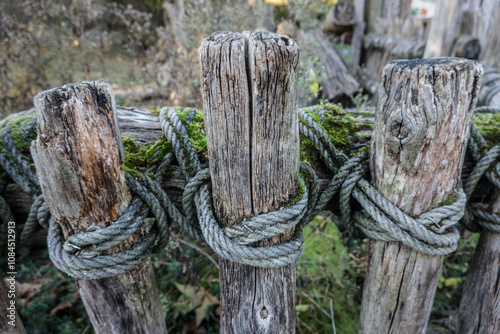 rustikaler Zaun aus Holzlatten und einem Seil photo