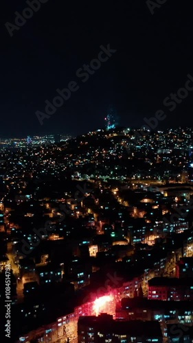 Vertical video of fireworks - aerial shot by drone of celebratory fireworks exploding over the city. Izmir, Turkey