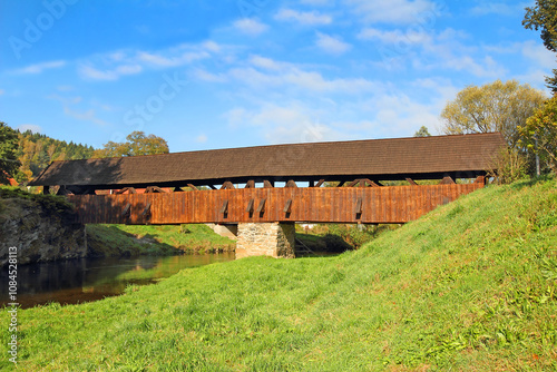 Obraz na płótnie River Svratka and wooden covered bridge built in 1718. It is the oldest covered wooden bridge in Moravia, Cernvir Village, Highlands Region, Czech Republic w salonie