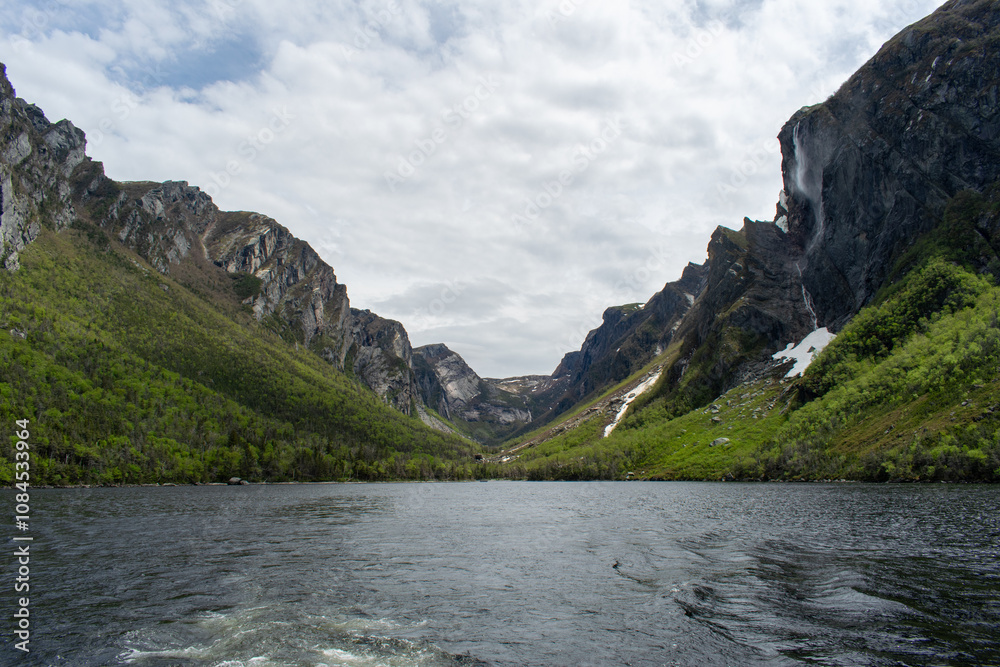 At the eastern end of Western Brook Pond, where the fjord meets, the serene waters and majestic cliffs highlight the breathtaking beauty of Gros Morne National Park. At the eastern end of Western Brook Pond, where the fjord meets, the serene waters and majestic cliffs highlight the breathtaking beauty of Gros Morne National Park.