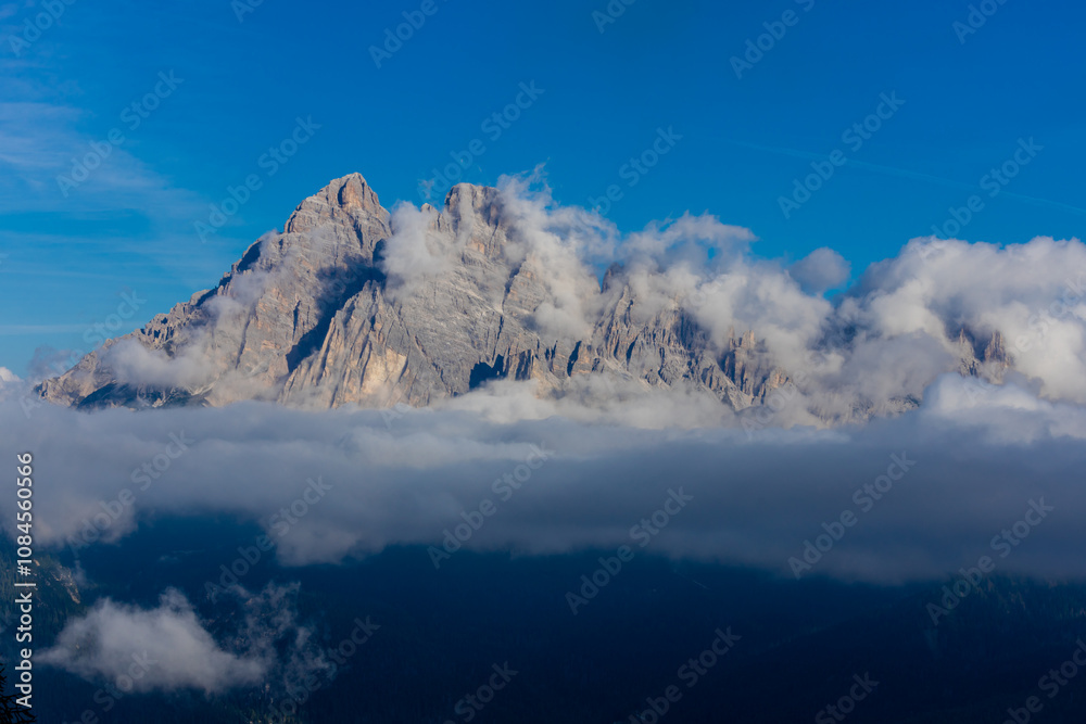 Obraz premium Mountains above the clouds stunning landscape. High rocky peaks rising through mist, this scene captures dramatic high-altitude views with soft cloud cover and rugged terrain in Dolomiti Alps