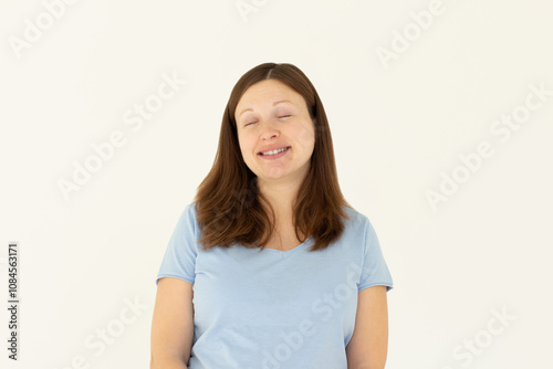 Beautiful caucasian woman dreamy smiling with eyes closed, standing relaxed and happy against white background. Copy space