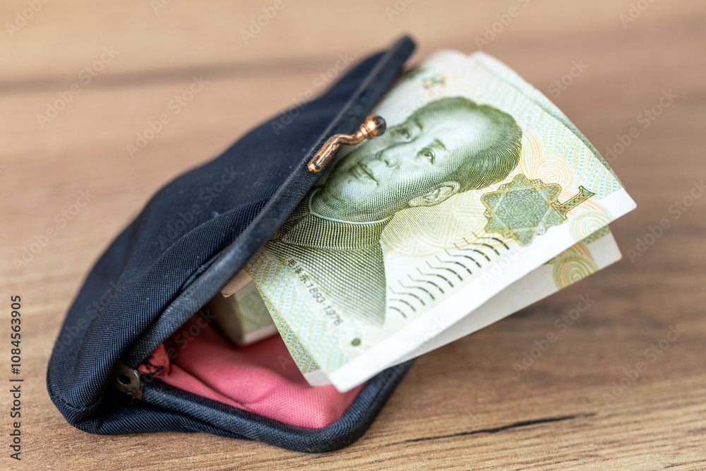 China money. Old purse and a roll of small money sticking out of it, Financial concept. A few yuan, close up