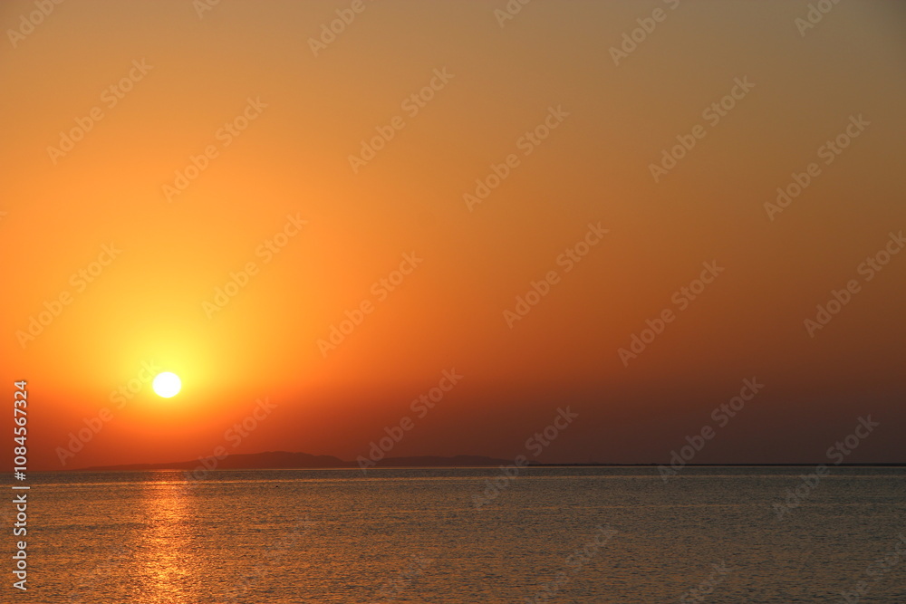 Sunrise over the sea. Sunset above ocean. Sun rising over the surface of sea Sunrise over the sea. Sunset above ocean. Sun rising over the surface of sea