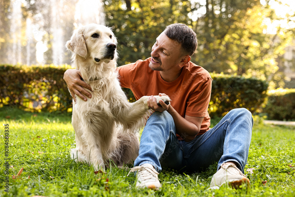 Smiling man with cute Golden Retriever dog on spring day Smiling man with cute Golden Retriever dog on spring day