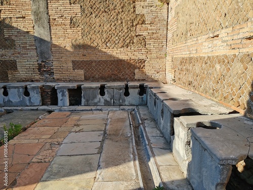 Ostia Antica, Rome, Italy - November 3, 2024, view of the public toilets, called vespasiani (the vespasian), in the Archaeological Park of Ostia Antica. photo
