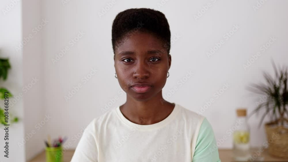 Close up portrait of young confident black woman looking at camera sitting at home office workplace Close up portrait of young confident black woman looking at camera sitting at home office workplace