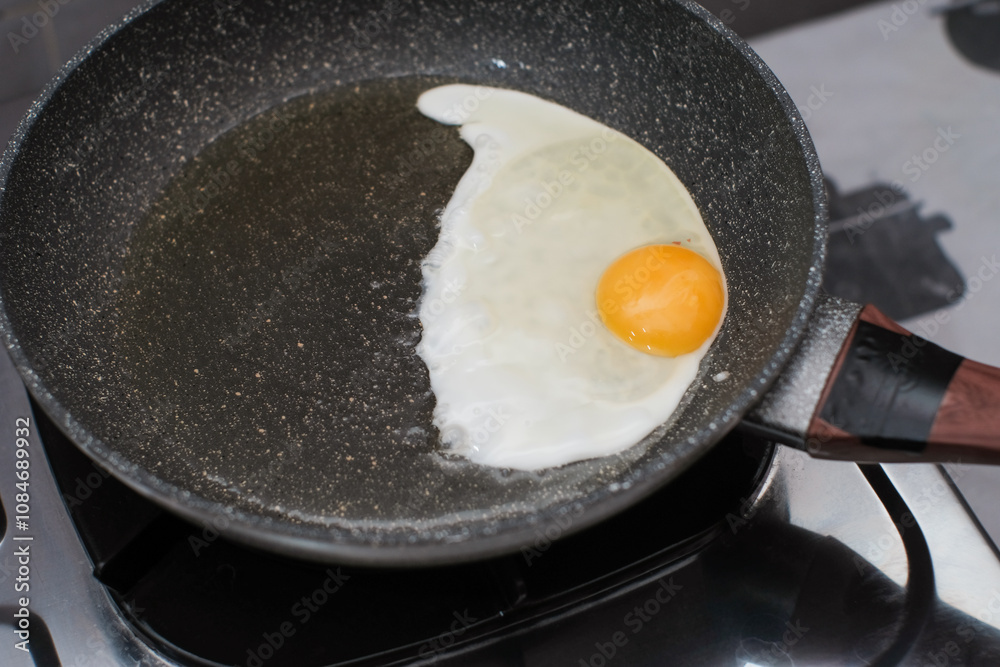 Fried egg. Close up view of the fried egg on a frying pan on gas stove, cooking egg homemade. Fried egg. Close up view of the fried egg on a frying pan on gas stove, cooking egg homemade.