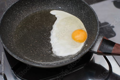 Fried egg. Close up view of the fried egg on a frying pan on gas stove, cooking egg homemade.
