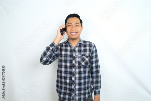 portrait of smiling asian man talking on smartphone wearing casual shirt isolated on white