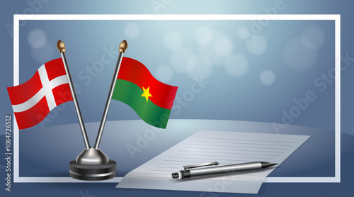 Denmark and Burkina National flags on small table with bokeh background, cooperative relationship