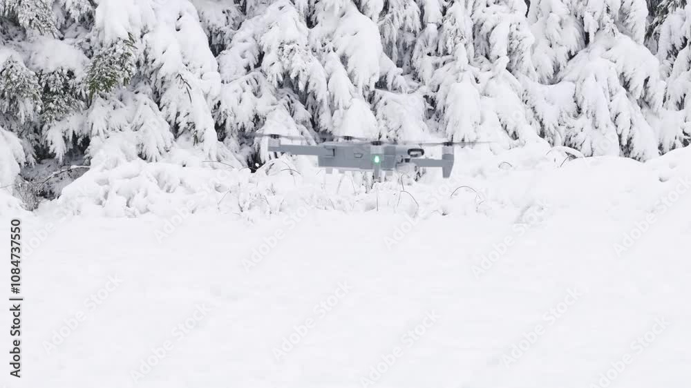 Flying gray drone in the winter forest. Flying gray drone in the winter forest.