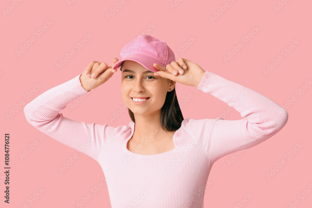 Beautiful young woman in stylish pink cap on color background Beautiful young woman in stylish pink cap on color background