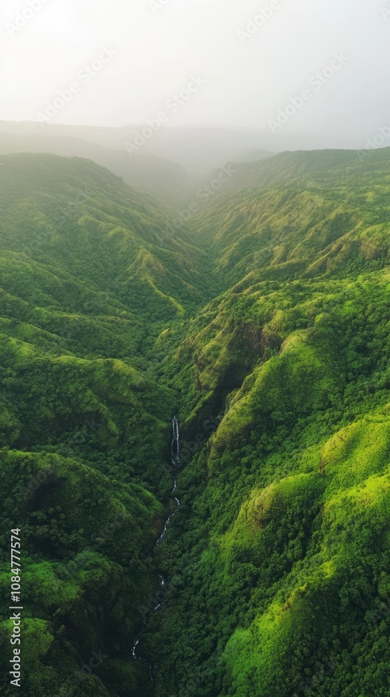 Fototapeta premium Waterfall flowing through lush green valley in kauai, hawaii