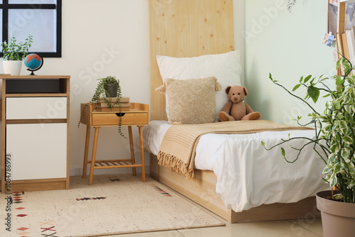 Stylish interior of modern children's room with comfortable bed and houseplants photo