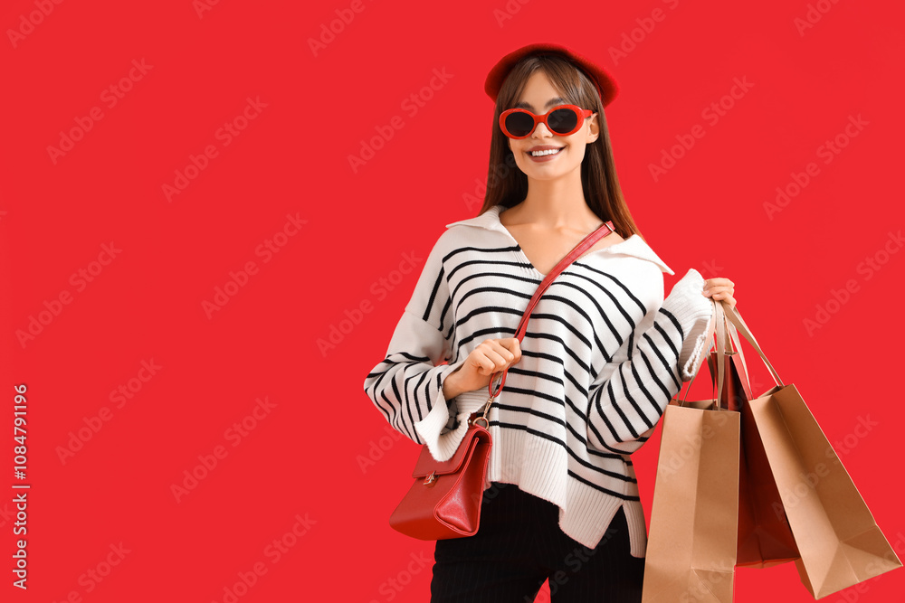 Stylish young woman with shopping bags on red background. Black Friday Sale Stylish young woman with shopping bags on red background. Black Friday Sale
