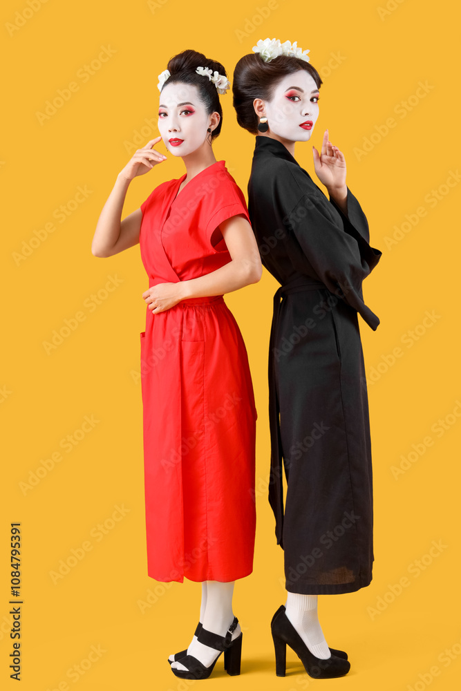 Beautiful young geishas on yellow background Beautiful young geishas on yellow background