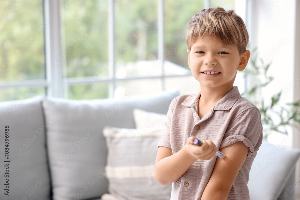 Little diabetic boy using lancet pen at home Little diabetic boy using lancet pen at home