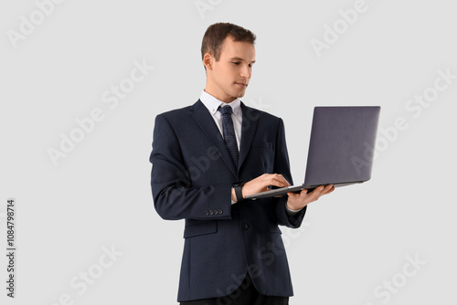 Handsome businessman in suit working with laptop on white background