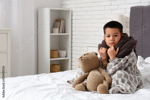 Ill little Asian boy with s...