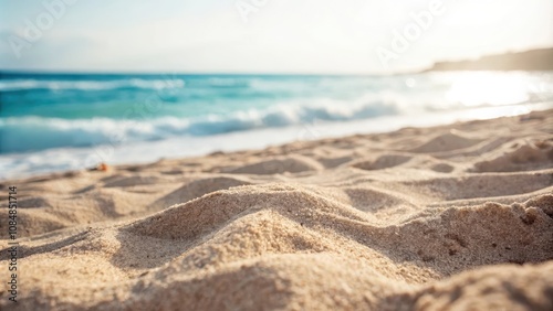 A Close-Up View of Golden Sand on a Sunny Beach with Ocean Waves in the Background