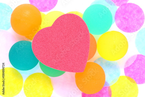 Red heart on Coloured rubber ball on polka dot background. Rea heart on coloured rubber ball on polka dot background Shallow depth of field Rubber ball is semi translucent.Copyspace on large red heart photo