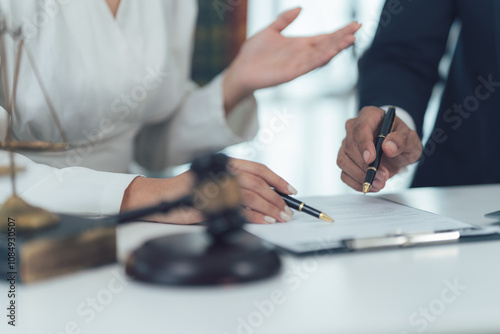 Legal Consultation:  A close-up shot of a lawyer and client reviewing legal documents, emphasizing the meticulous attention to detail and collaborative approach in seeking justice.   photo