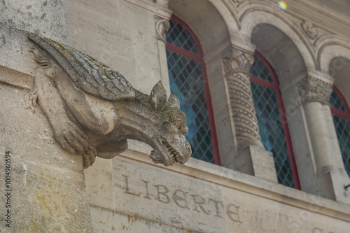 une chimère sculptée dans la pierre au dessus du mot Liberté photo