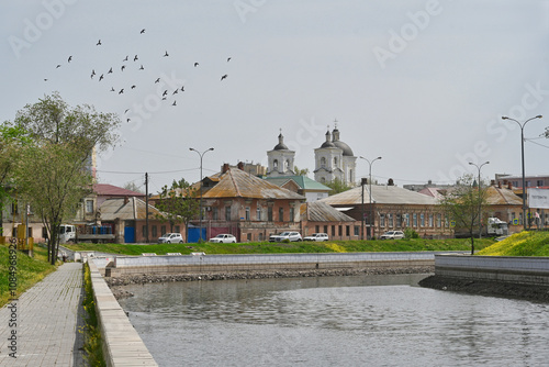 Water canal embankment with the Catholic Assumption Church view in Astrakhan