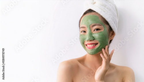 Radiant Beauty: A young woman with a vibrant green face mask smiles radiantly, showcasing a confident and healthy glow. This captivating image evokes a sense of self-care and rejuvenation. photo