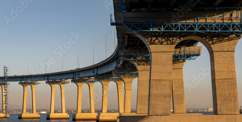 Pillars of the Coronado Bridge from Coronado Island, California with sunlight reflecting off concrete during the blue hour taken in October 2024