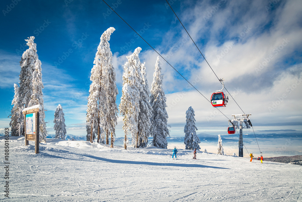 Ski gondolas above the skiers on the ski slope, Romania