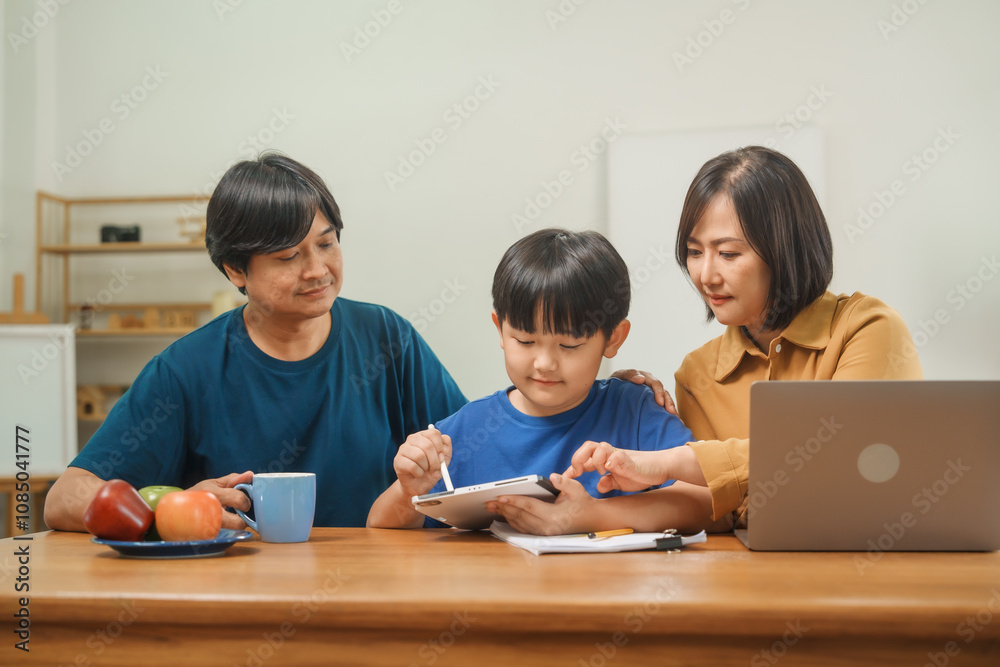 Asian parents and their children sit together at the table in the morning, studying online using tablets and computers, fostering a productive and focused family learning environment Asian parents and their children sit together at the table in the morning, studying online using tablets and computers, fostering a productive and focused family learning environment