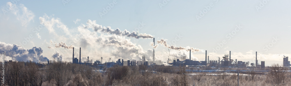 A large industrial city with smoke billowing from the factories A large industrial city with smoke billowing from the factories