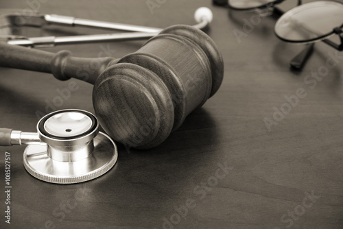 Wooden gavel and stethoscope on wooden background, copy space. Malpractice concept.	 photo