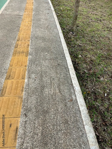 Wallpaper Mural A concrete pathway with a tactile guide for visually impaired individuals. Torontodigital.ca