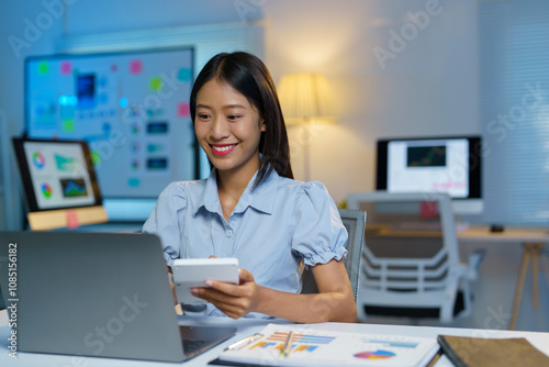 Asian businesswoman works on laptop and calculates with financial calculator from graphs, statistics, charts. Planning. Business success results in modern office.