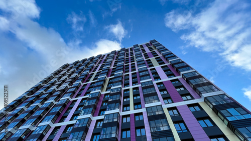 The facade of the building in purple,geometric patterns from windows and balconies, the colored wall of a modern multi-storey residential building, the abstract texture of the facade of the house