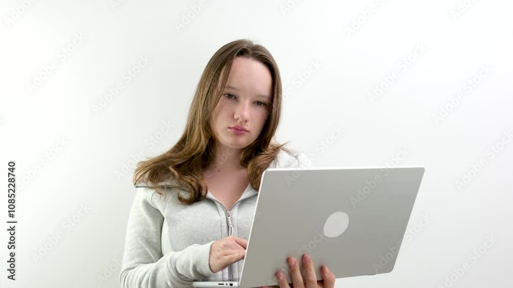 young teenage girl typing on laptop. stand on white background hold gadget in hands search internet links learn online. order online delivery young teenage girl typing on laptop. stand on white background hold gadget in hands search internet links learn online. order online delivery