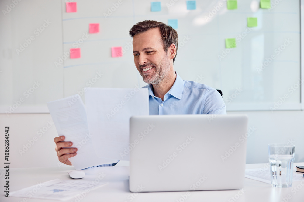 Businessman reviewing documents at office desk Businessman reviewing documents at office desk