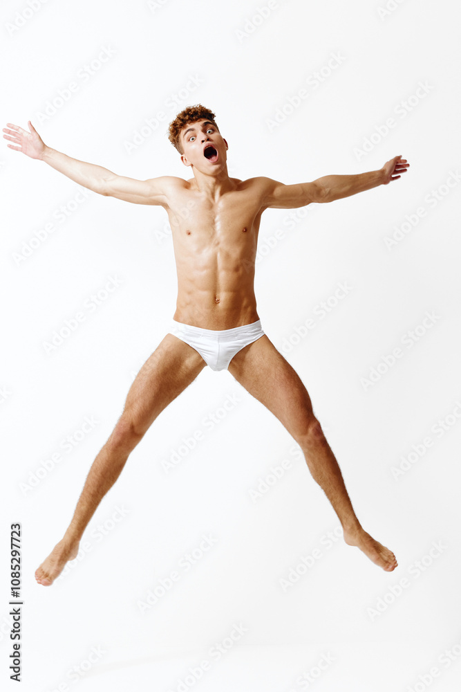 Excited young man jumping in mid-air, expressing joy and energy with arms wide open. Concept of freedom, happiness, and active lifestyle on a white background. Excited young man jumping in mid-air, expressing joy and energy with arms wide open. Concept of freedom, happiness, and active lifestyle on a white background.