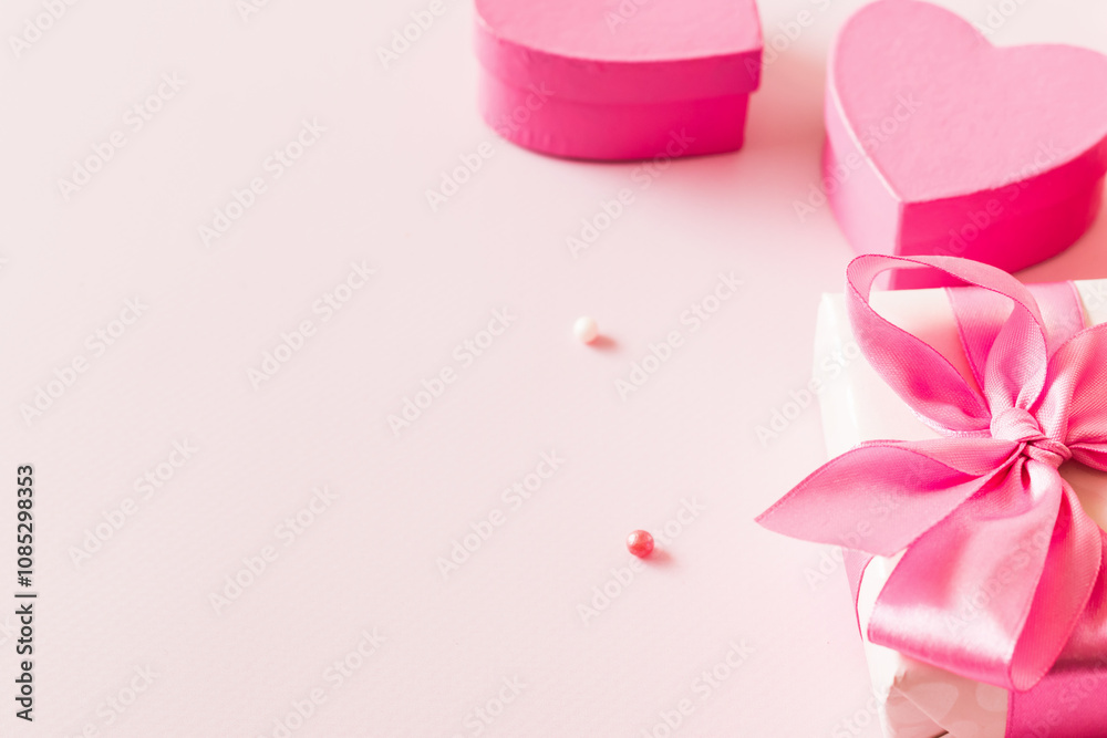 Pink hearts and gift box with ribbon on a light pink background Pink hearts and gift box with ribbon on a light pink background