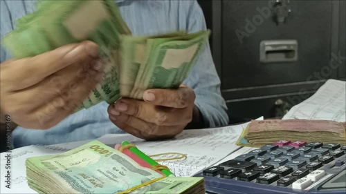 A cashier counts money at a microfinance institution in Bangladesh.  photo