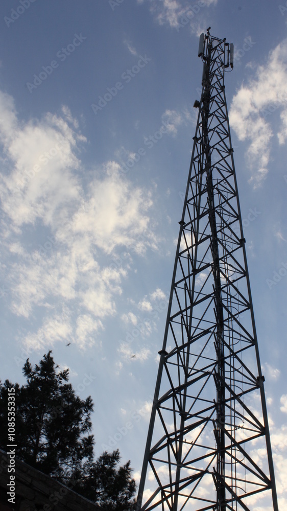 Large power tower against clear sky in desert landscape, symbolizing modern infrastructure in remote areas. Large power tower against clear sky in desert landscape, symbolizing modern infrastructure in remote areas.