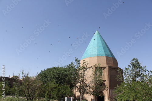 Birds flying above a turquoise dome, symbolizing peace and the timeless beauty of Middle Eastern architectural heritage. photo