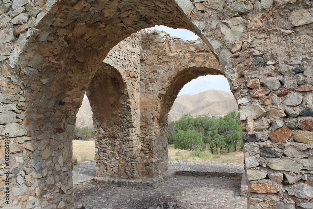 Stone arches in ruins with mountains in the background, symbolizing history amidst nature. Stone arches in ruins with mountains in the background, symbolizing history amidst nature.