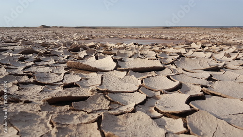 A wide view of cracked desert terrain with dramatic soil patterns, highlighting the harsh and rugged beauty of untouched arid landscapes.