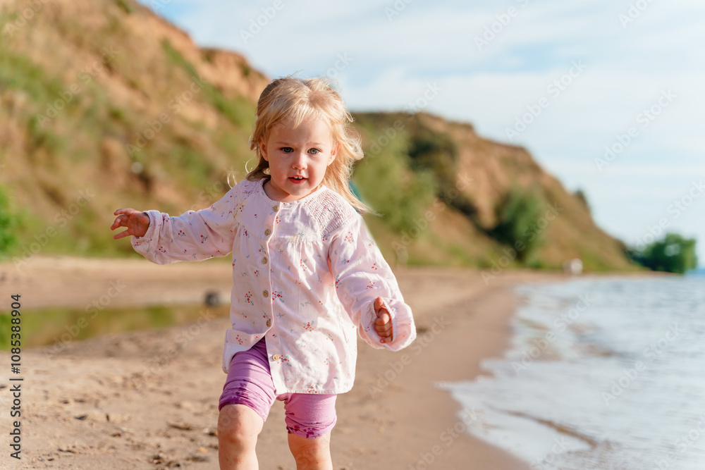 Little child toddler girl with a sunflower flower as a symbol of summer on the beach at sea at sunset. Little child toddler girl with a sunflower flower as a symbol of summer on the beach at sea at sunset.