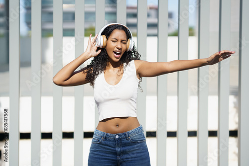 An Energetic Young Woman Joyfully Enjoying Her Favorite Music While Wearing Headphones